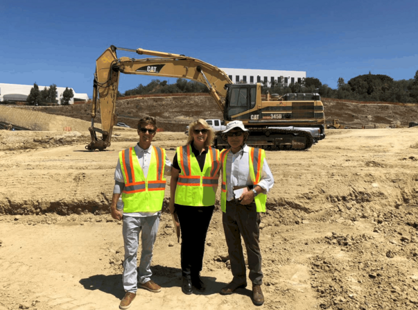 Construction workers in front of heavy machinery